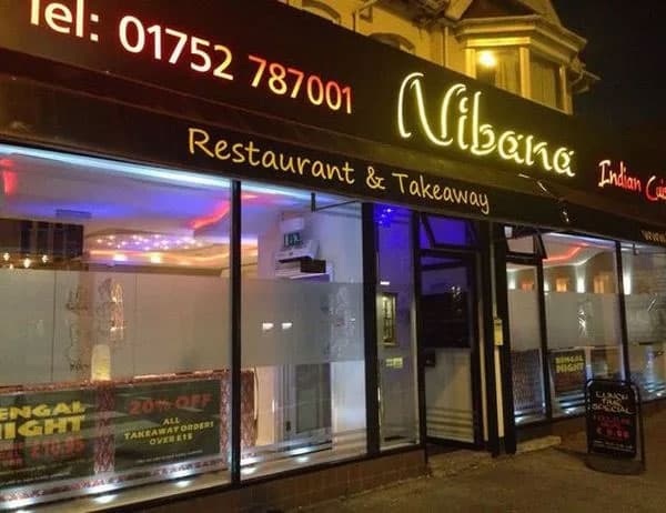The Nibana shopfront in Crownhill at dusk, the wordmark in pink neon